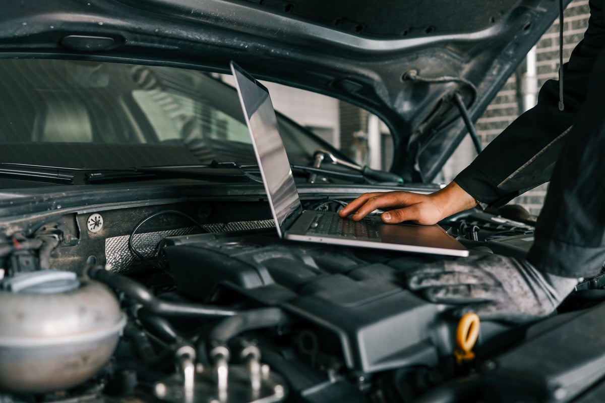 Mechanic using laptop for vehicle diagnostics